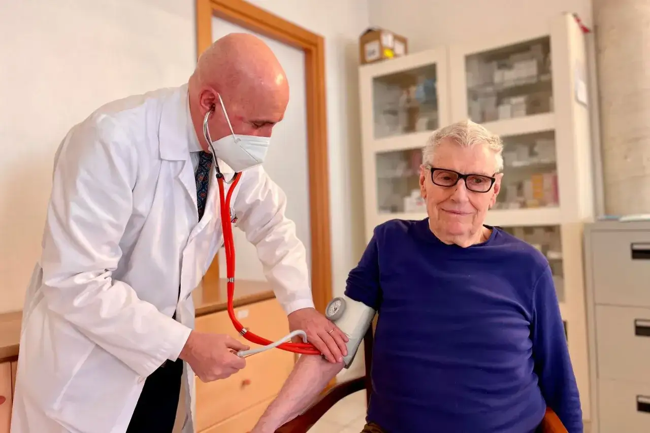 Medico controlla la pressione bassa di un anziano di 80 anni.