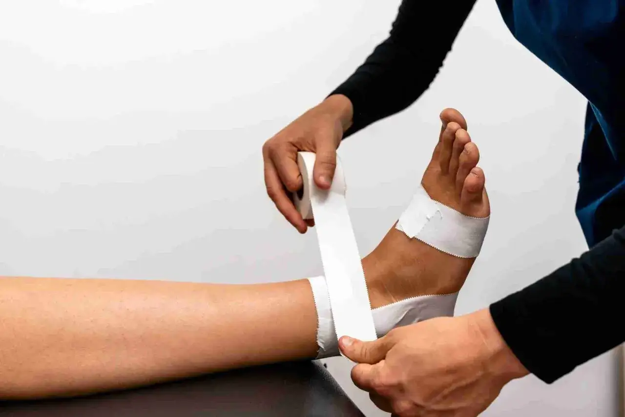 Applicazione di un bendaggio ossido di zinco sulla caviglia per supporto e protezione.