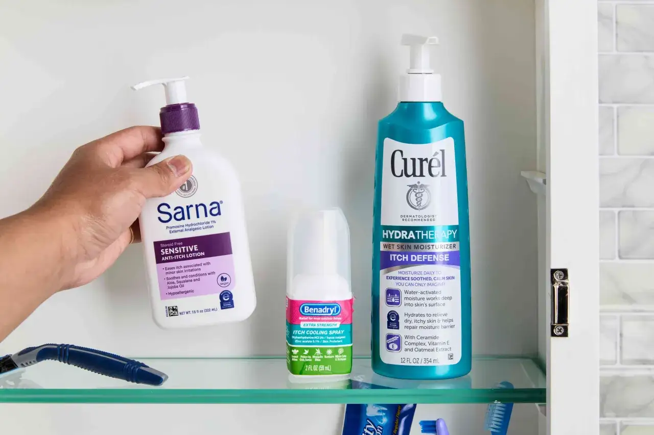 Prodotti per alleviare il prurito: una mano tiene una lozione Sarna, accanto a uno spray Benadryl e un idratante Curél, tutti antistaminici per prurito.