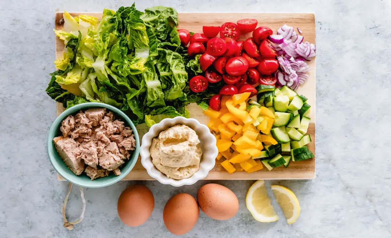 Ingredienti per un'insalata: lattuga, pomodorini, cipolla, cetrioli, peperoni, tonno in scatola, uova e limone. Con la diarrea si può mangiare il tonno in scatola.