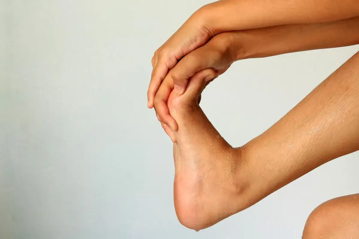 Mani che massaggiano un piede, forse per alleviare i sintomi della cattiva circolazione sanguigna e le sue conseguenze.