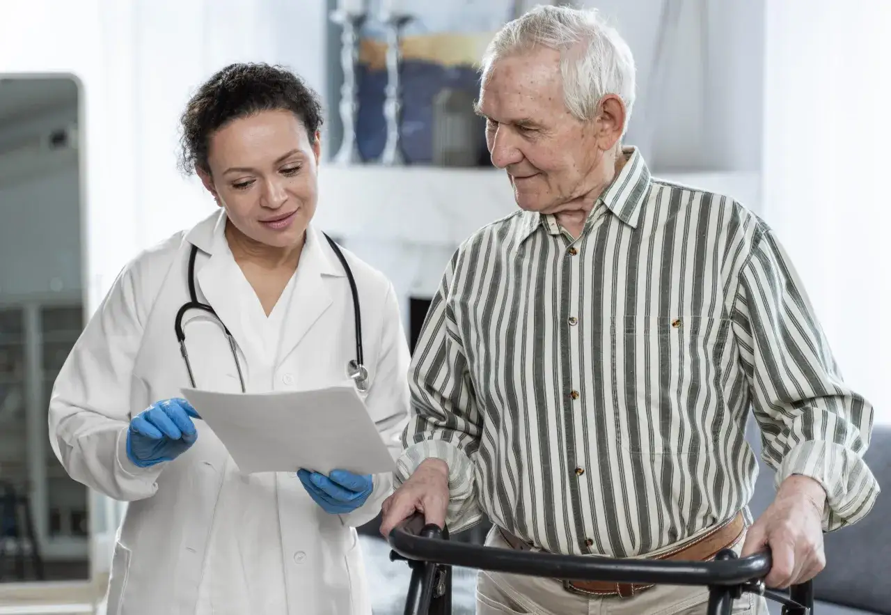 Medico spiega a paziente anziano con deambulatore possibili problemi cognitivi cause e soluzioni.