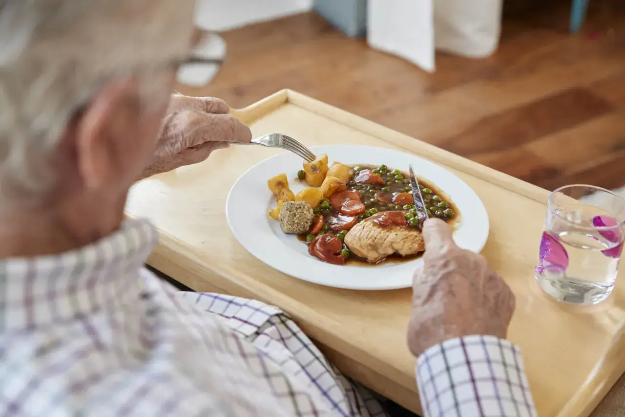 Un uomo anziano mangia un pasto equilibrato, ideale per una dieta per anziani over 90.
