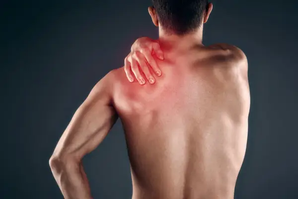 Uomo con mano sulla spalla, evidenziata in rosso, che indica dolore muscolare, forse mialgia da farmaci.
