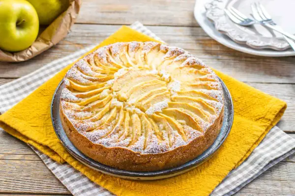 Torta di mele fatta in casa, perfetta come dolci per diabetici. Decorata con fettine di mela e zucchero a velo.