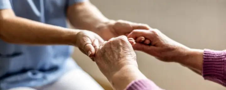 Mani che si stringono, un gesto di cura e supporto. Un'immagine che evoca il valore del bonus caregiver e l'importanza di chi assiste gli altri.